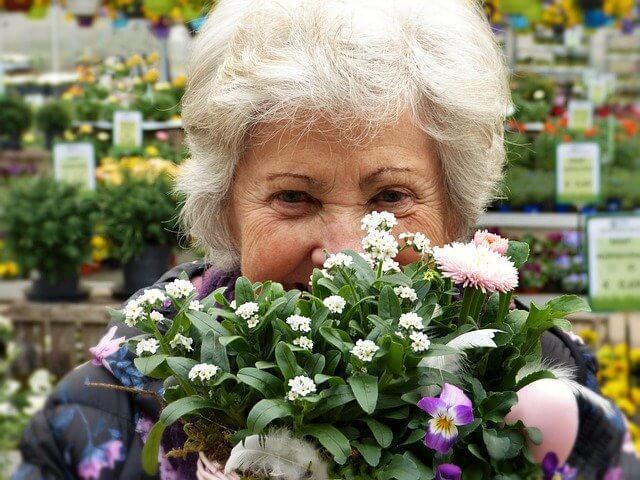 高齢の女性が笑顔で花束を持っている写真