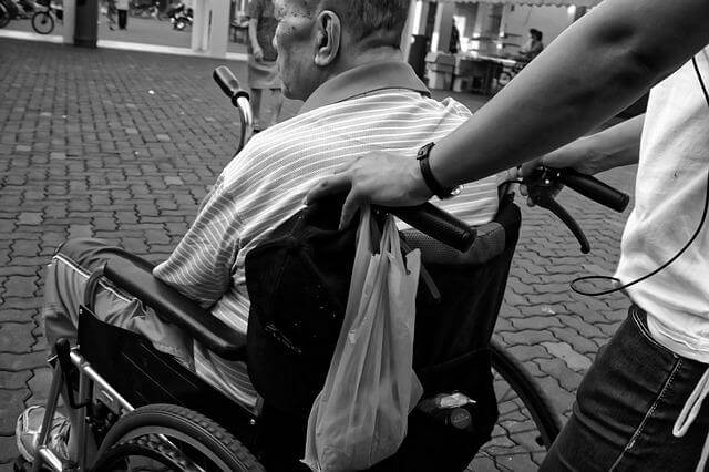 買い物をした車椅子の高齢者と介護者の写真