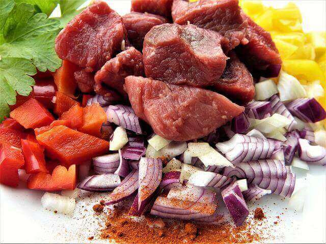 カットされた色とりどりの野菜の上に赤肉が載っている写真