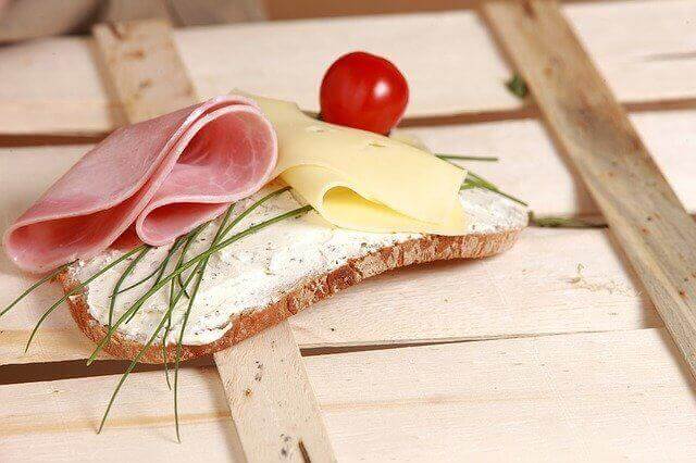 食パンにハム、チーズ、ミニトマトが載ってるサンドイッチの写真