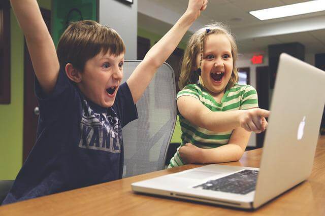 パソコン画面を見て喜んでいる男の子と女の子